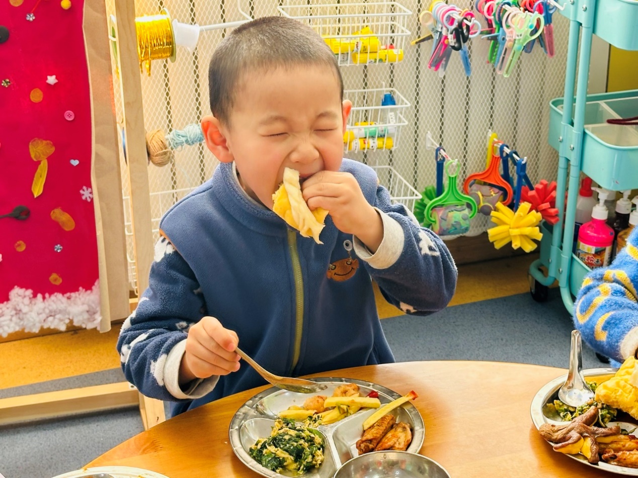 桌子前吃东西的小孩中度可信度描述已自动生成